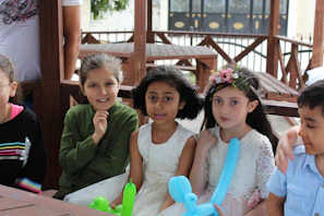 Children laughing together, dressed in ballet costumes during a birthday party celebration