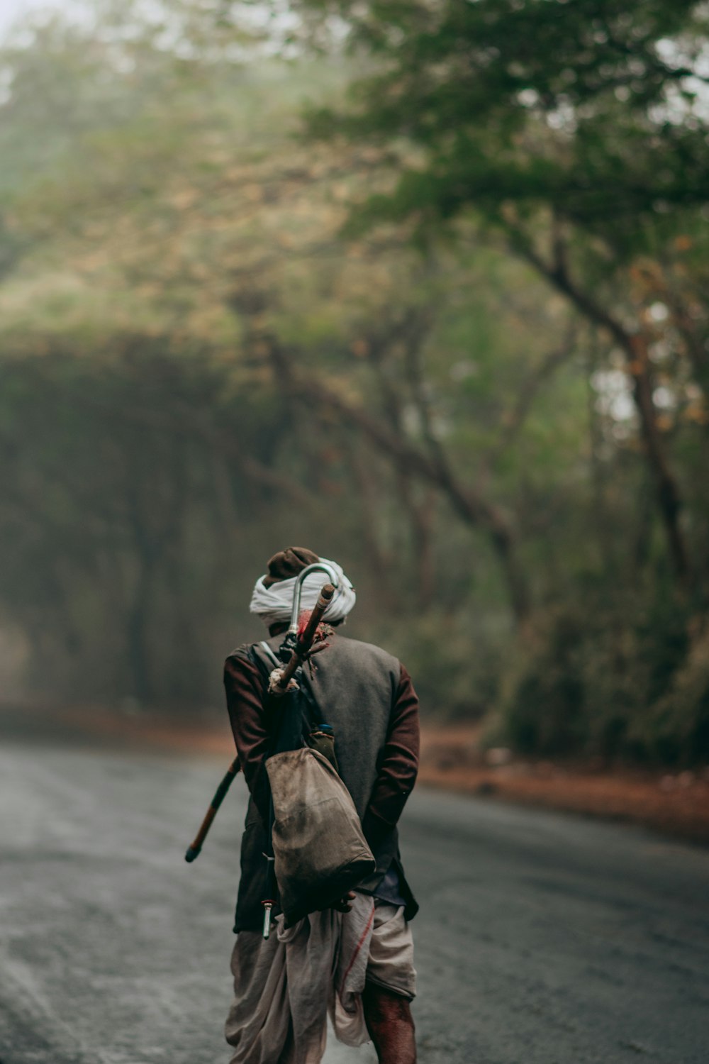 man in black and red jacket wearing white helmet standing on road during daytime