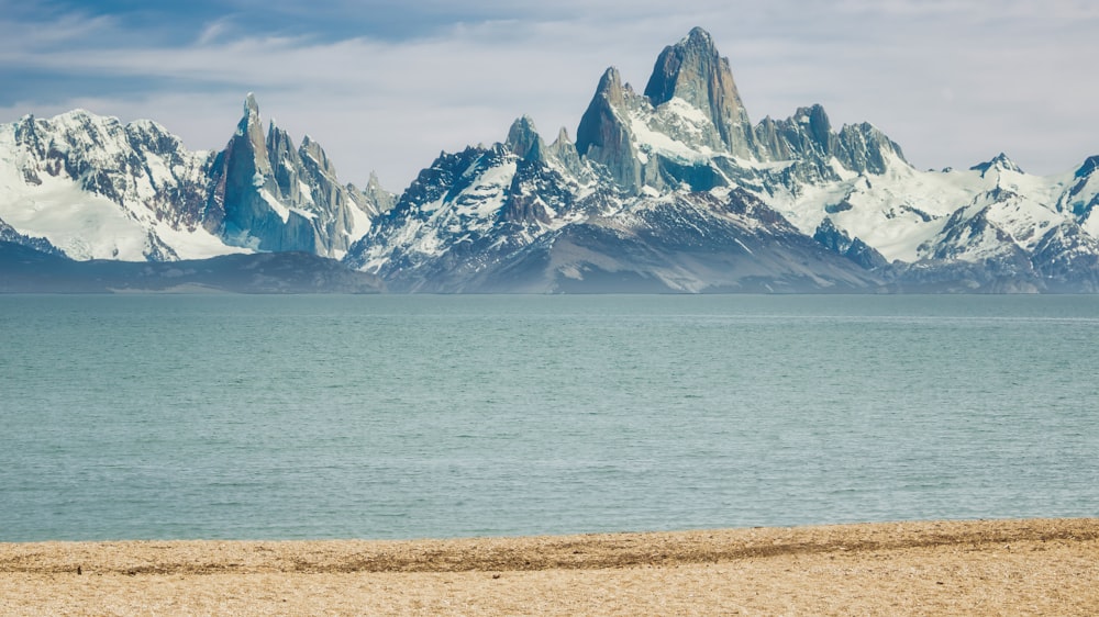 Montaña cubierta de nieve cerca del cuerpo de agua durante el día