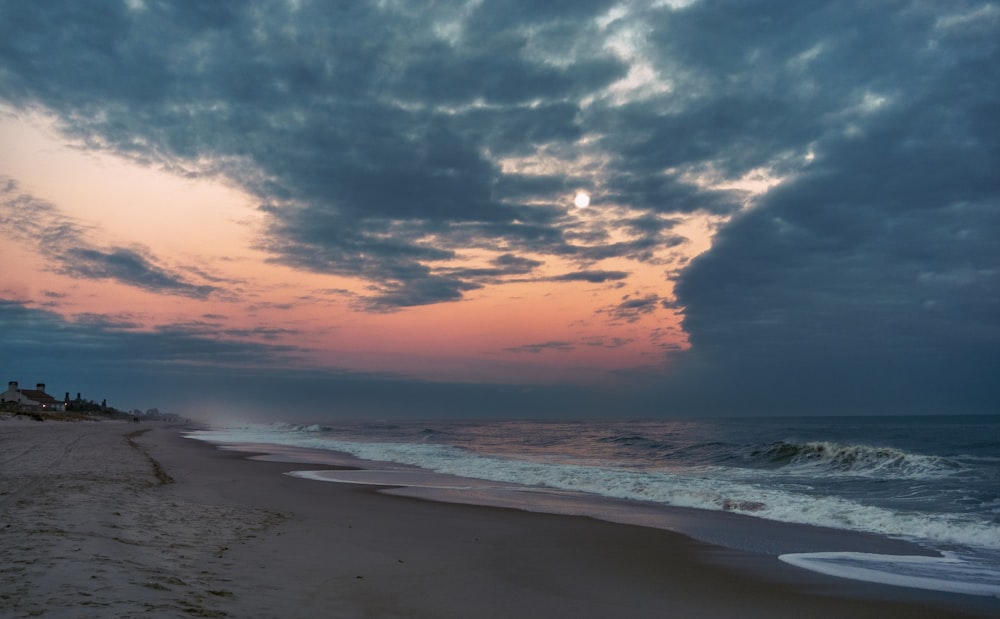 sea waves crashing on shore during sunset