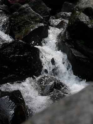 Close-up of a waterfall cascading over mossy rocks in the early morning light.