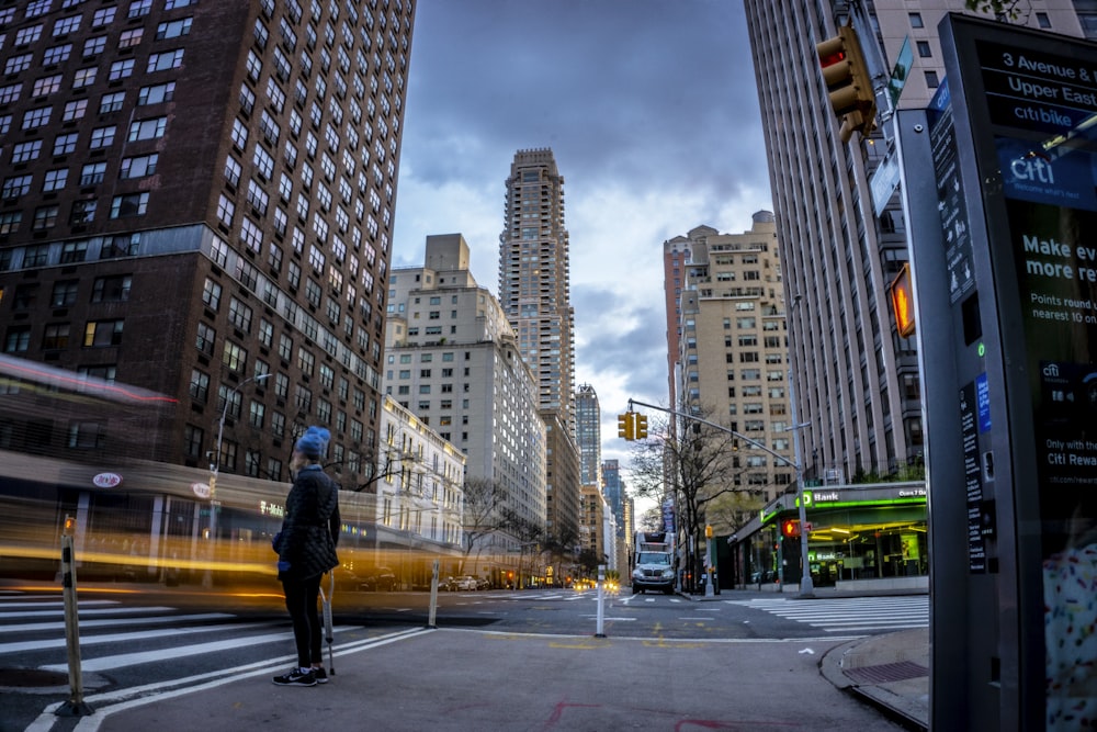 man in black jacket standing on sidewalk during daytime