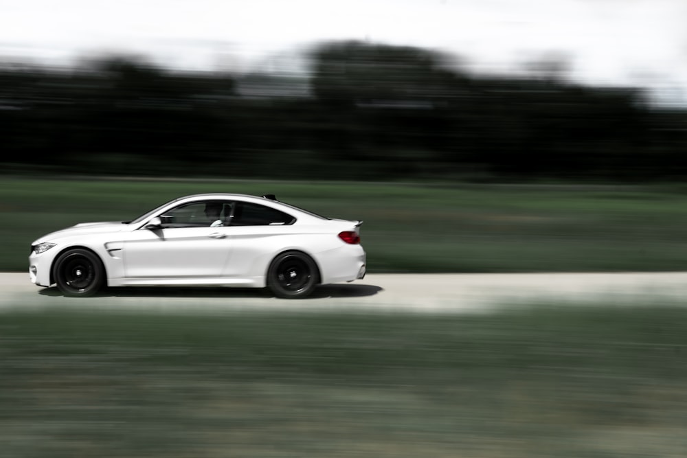 white coupe on road during daytime