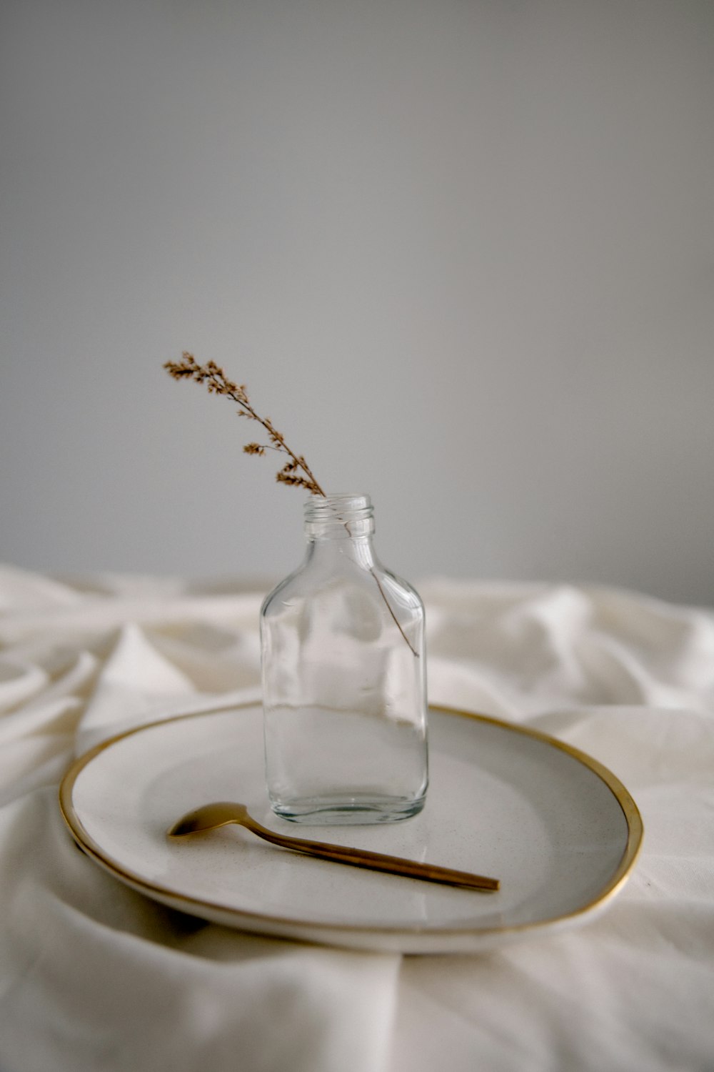 clear glass bottle on white textile