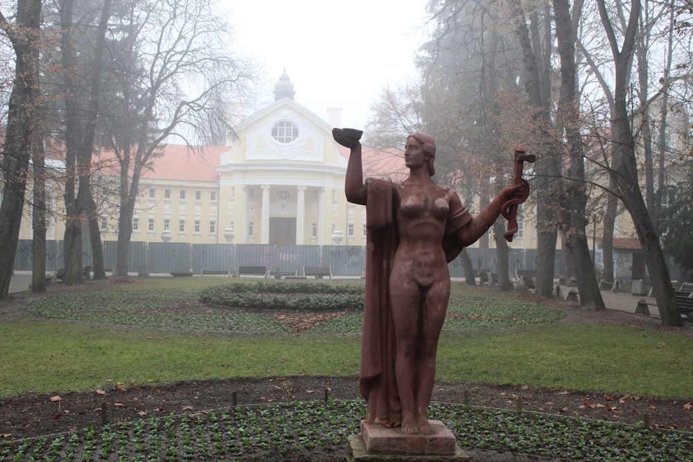 brown statue of man raising his right hand