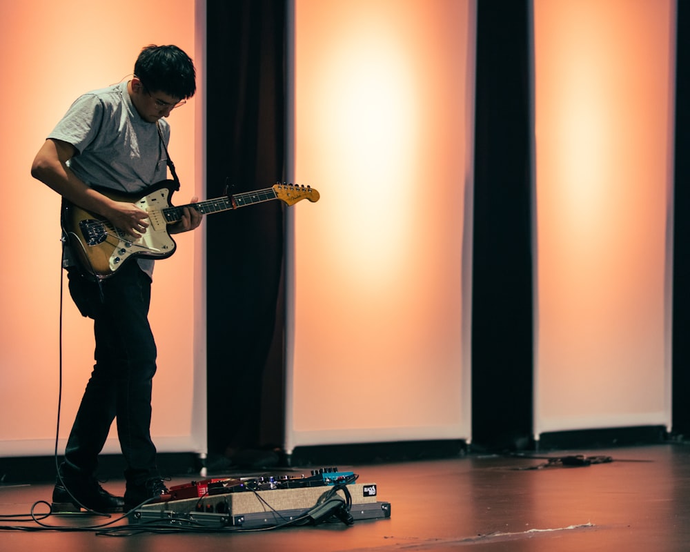 man in blue dress shirt playing electric guitar