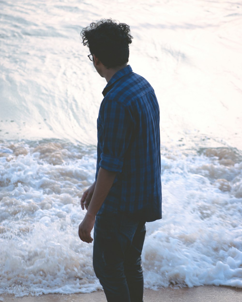 man in blue and white stripe shirt standing on white snow covered ground during daytime