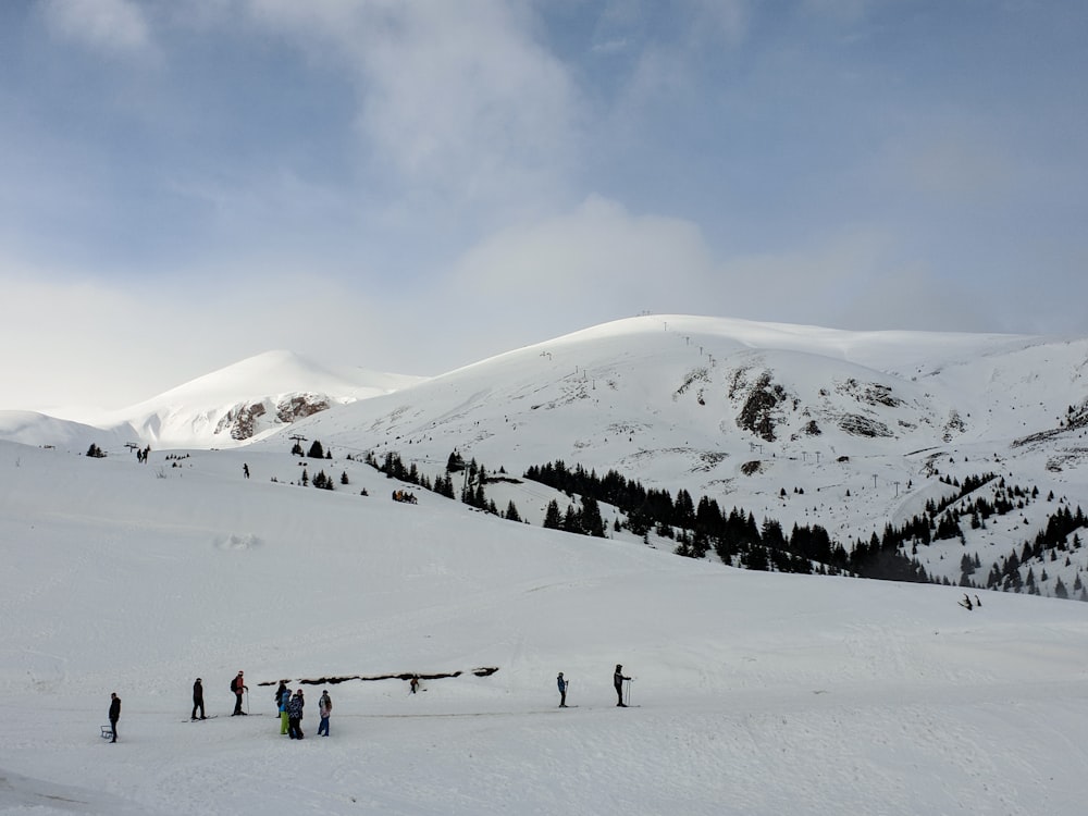 people walking on snow covered mountain during daytime