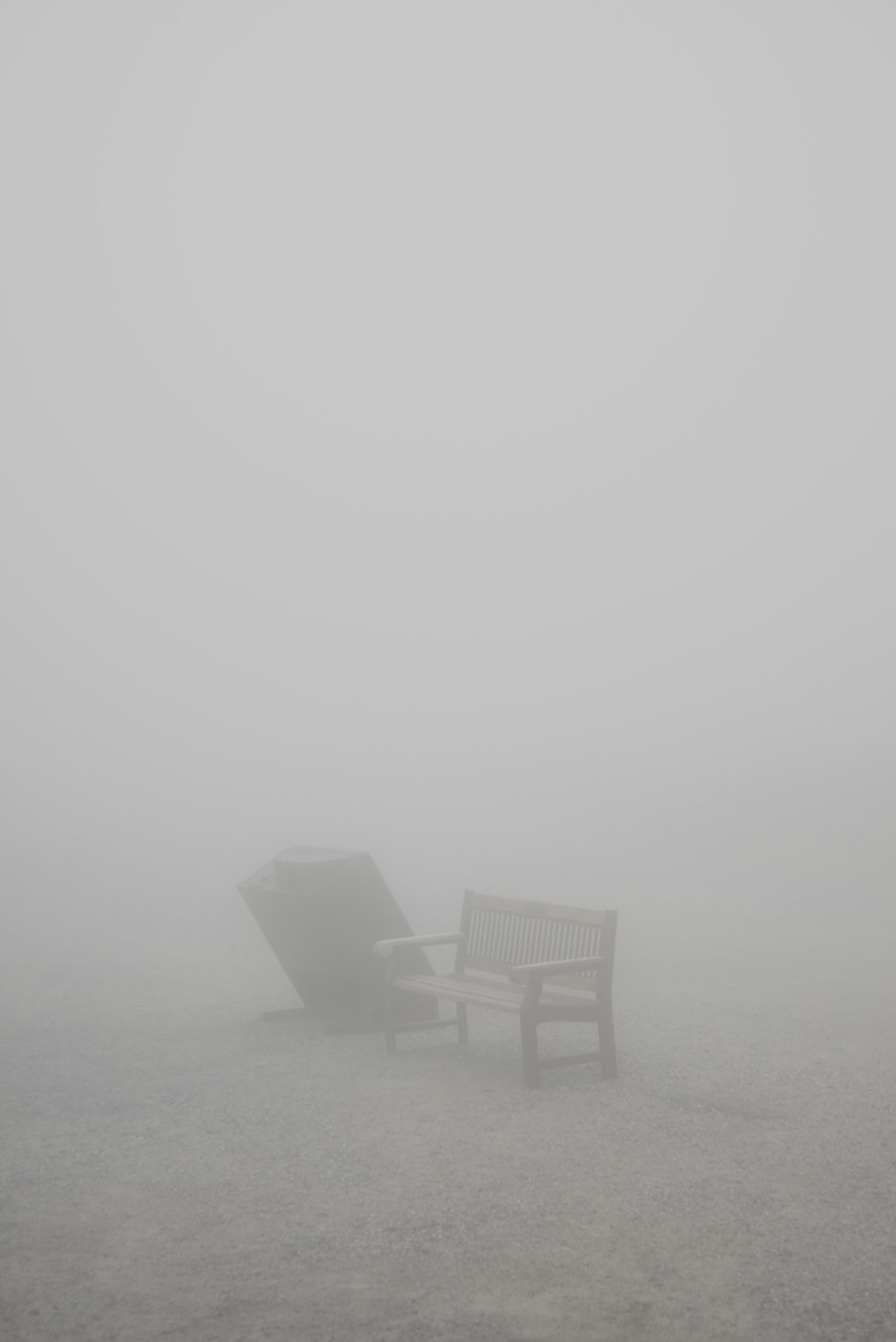 two brown wooden armchairs on brown sand