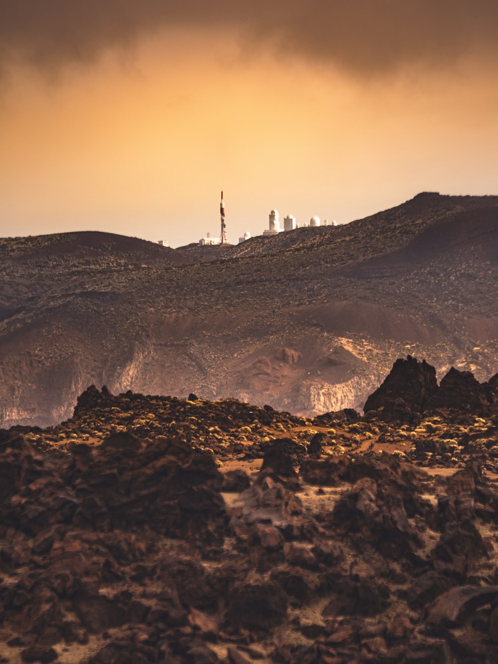 silhouette of person standing on rock formation during sunset