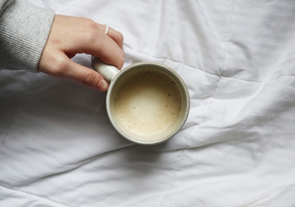 person holding white ceramic mug