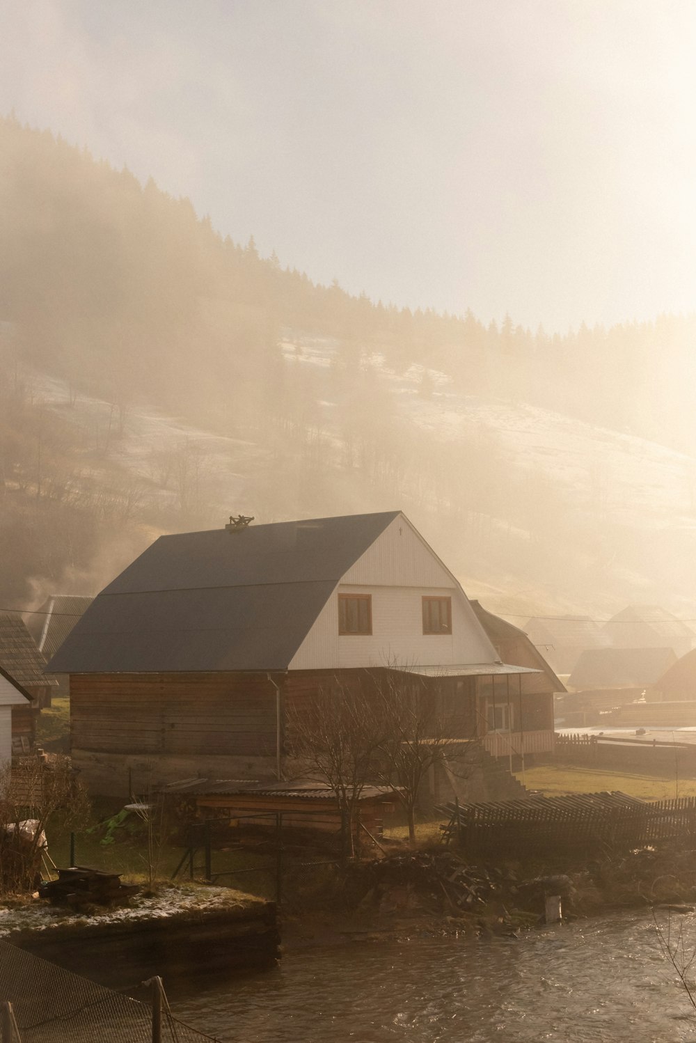 brown wooden house near body of water during daytime