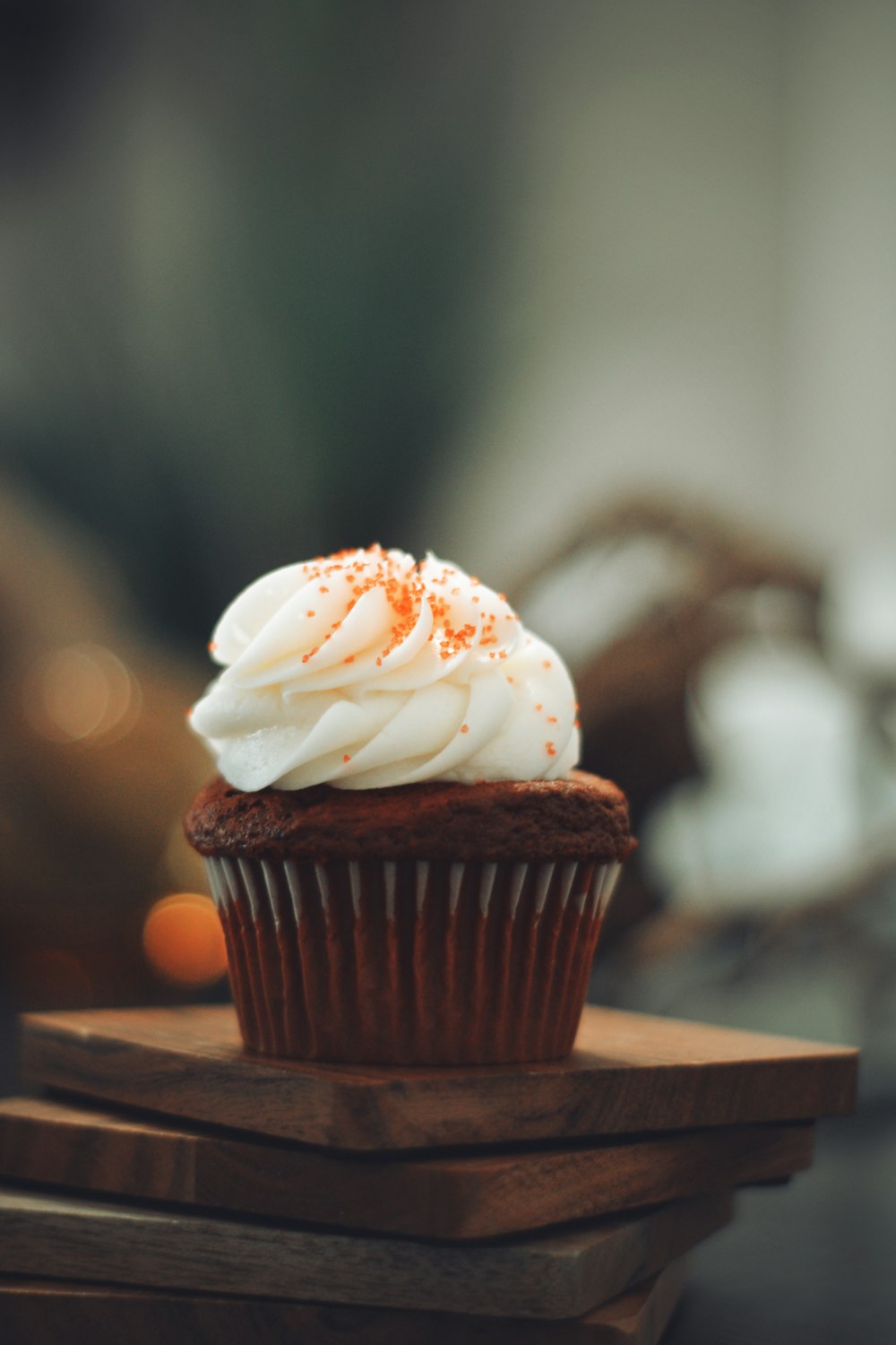 Cupcake avec glaçage blanc sur table en bois marron
