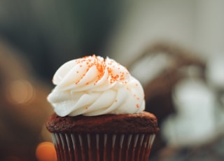 cupcake with white icing on brown wooden table