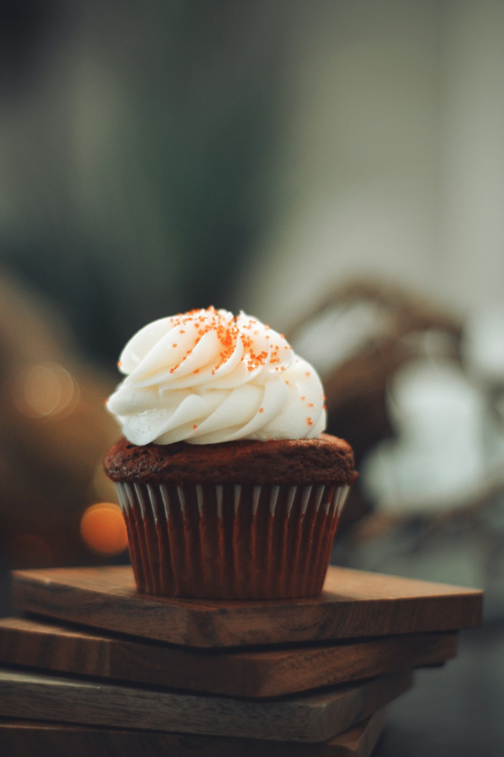 cupcake with white icing on brown wooden table