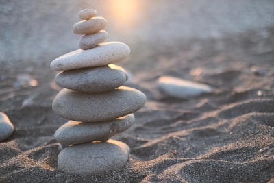 stack of stones on brown sand balanced teams background