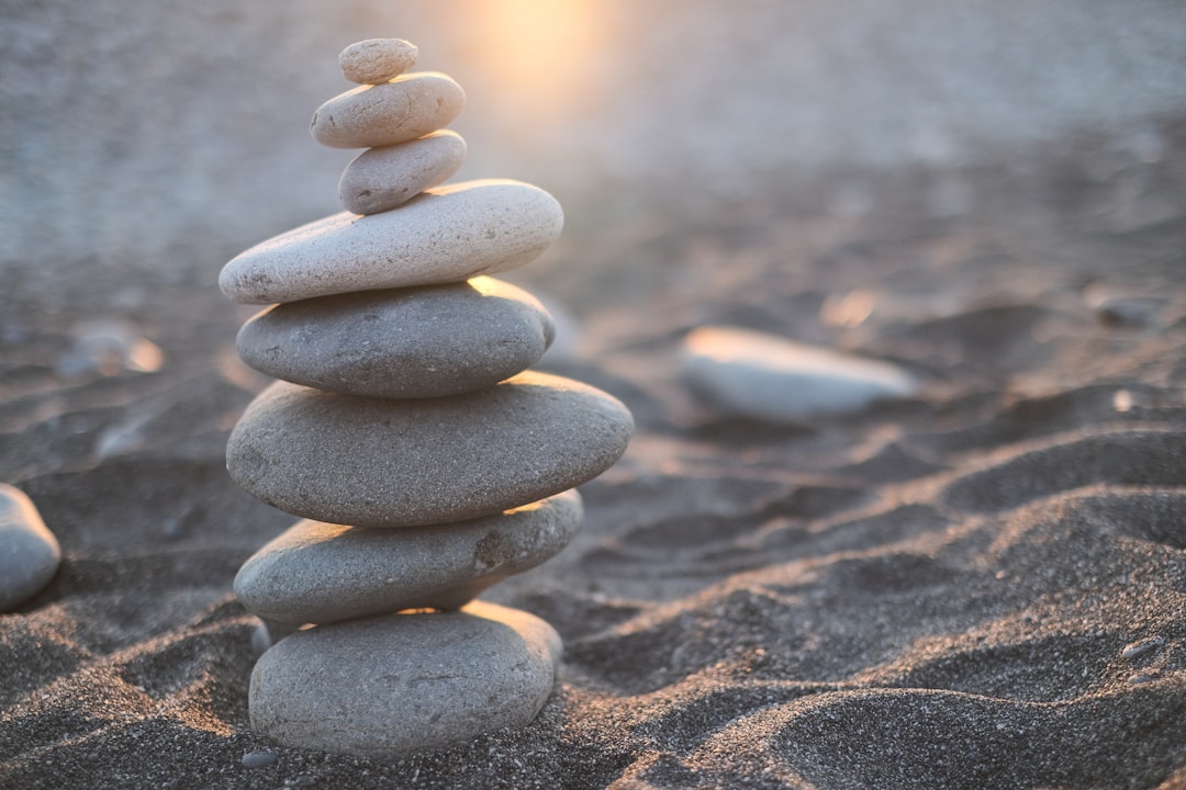  stack of stones on brown sand weighing balance