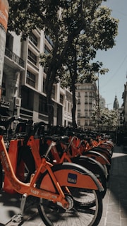 red and black bicycle parked on sidewalk during daytime