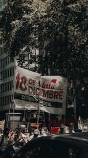 Street protest in Tlalpan with banners challenging government decisions.