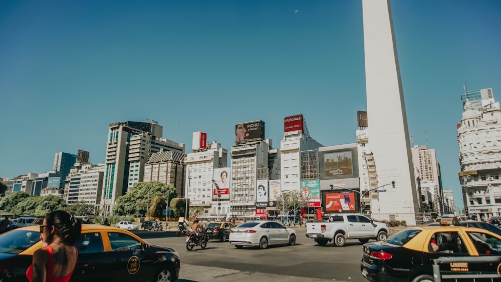 cars parked on side of the road near high rise buildings during daytime