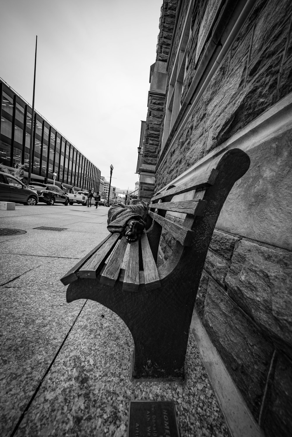 grayscale photo of bench near building