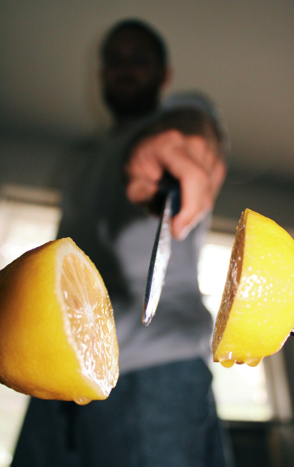 person holding stainless steel fork and sliced lemon