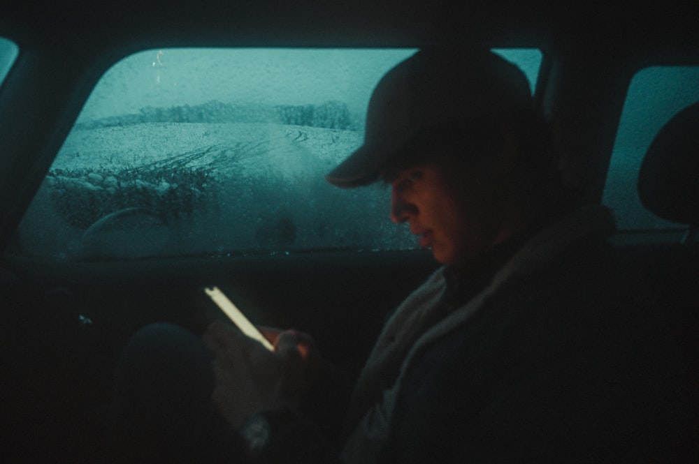 man in black jacket and black cap looking at the window