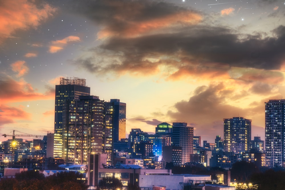 city skyline under cloudy sky during night time