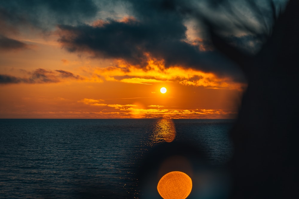 body of water under cloudy sky during sunset