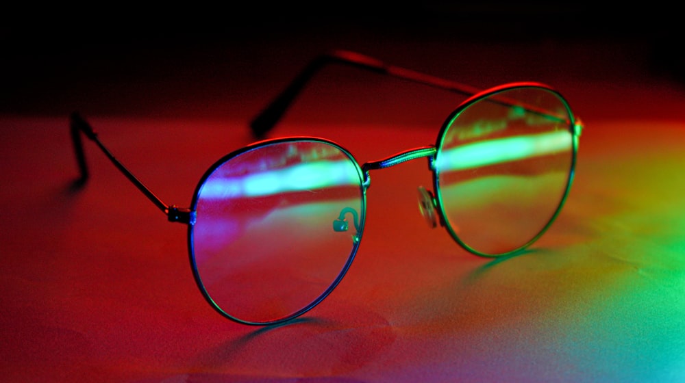 occhiali da sole con montatura nera su superficie rossa