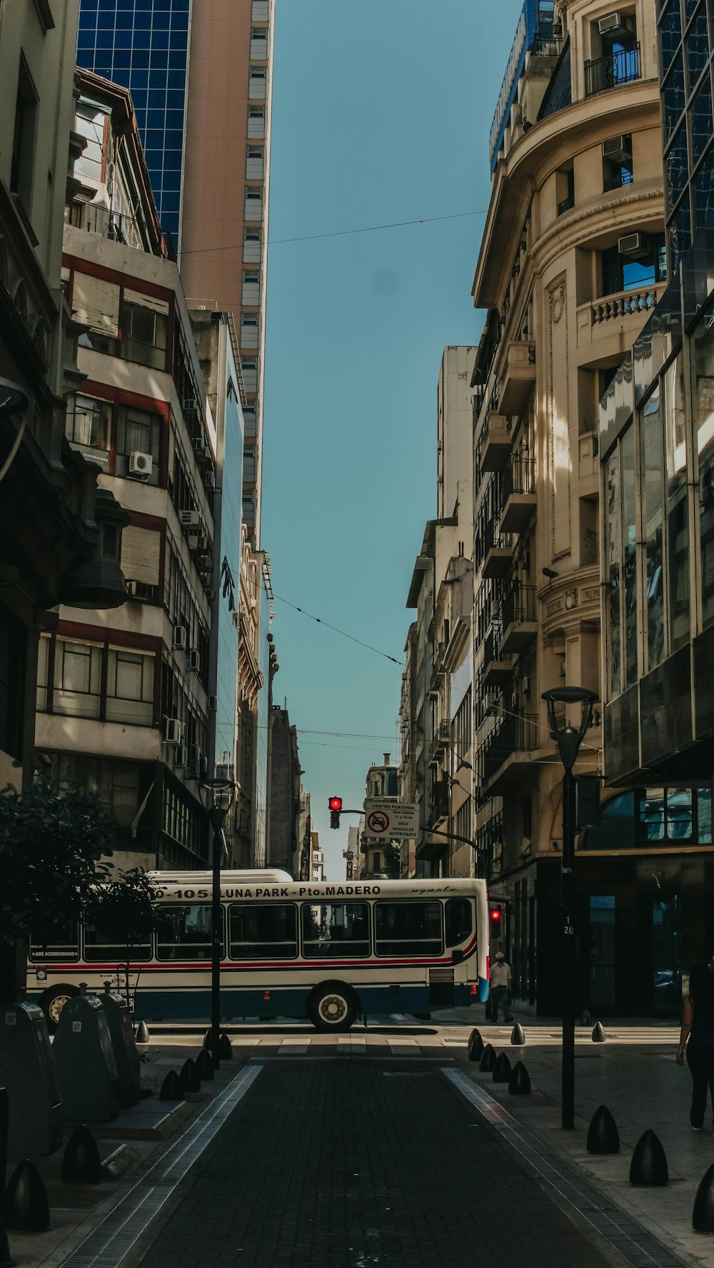 Autobus rosso e bianco sulla strada tra i grattacieli durante il giorno
