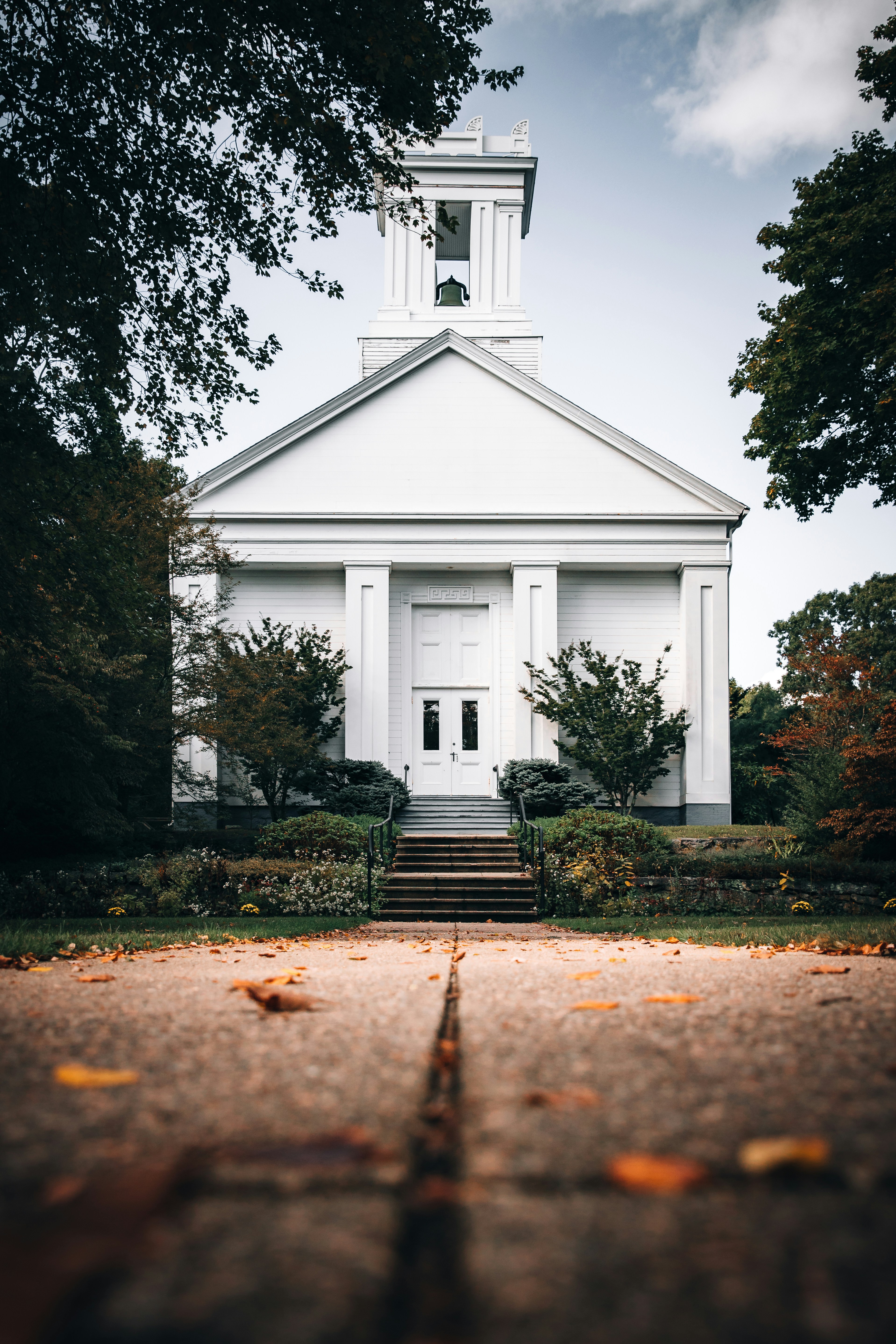 white and black church near green trees during daytime