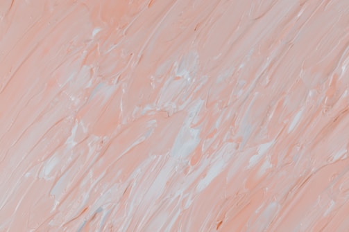 The image features a close-up of thick, textured brushstrokes in varying shades of pale peach and white, creating an abstract pattern. The brushwork appears dynamic, with a mixture of smooth and rugged textures, adding depth to the visual composition.