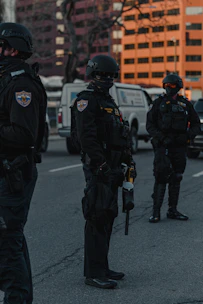 Police officers in training practicing tactical maneuvers outdoors.