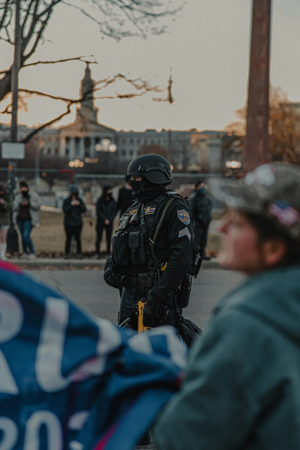 man in black jacket standing near people during daytime