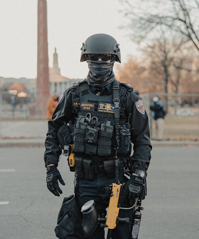 man in black and gray camouflage uniform holding black and brown rifle