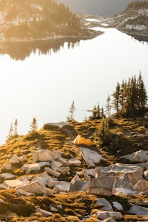 A cozy tent pitched beside a serene lake in the Canadian Rockies at sunrise