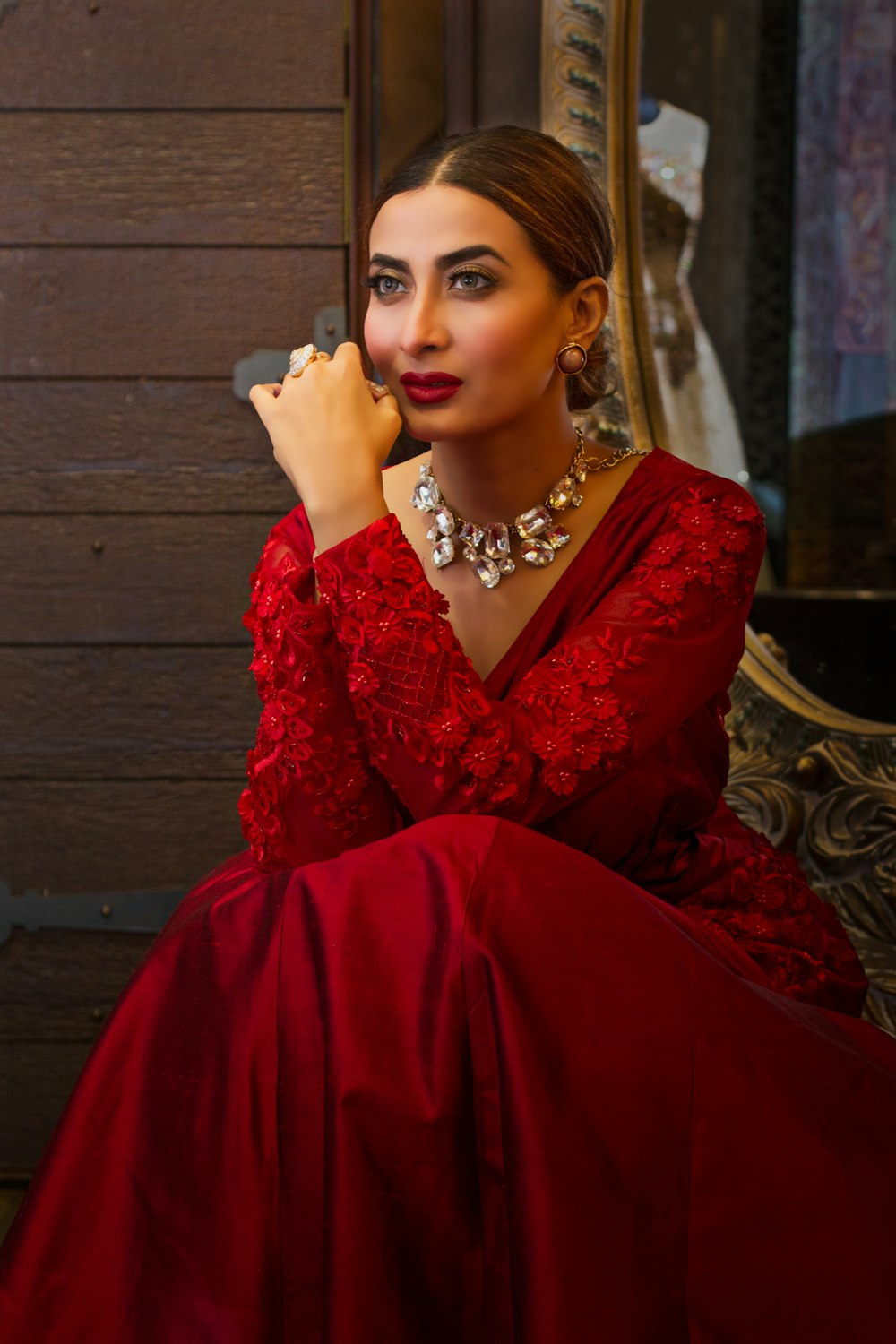 woman in red dress sitting on brown wooden bench