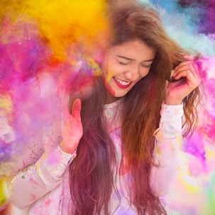woman in white long sleeve shirt with purple yellow and blue powder on her face