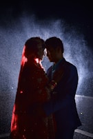 man in black suit kissing woman in red dress