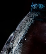 Close-up of a vibrant, fizzy elixr energy drink bottle with condensation drops.