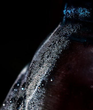 Close-up of a rich, dark coffee concentrate bottle with condensation droplets on the glass.