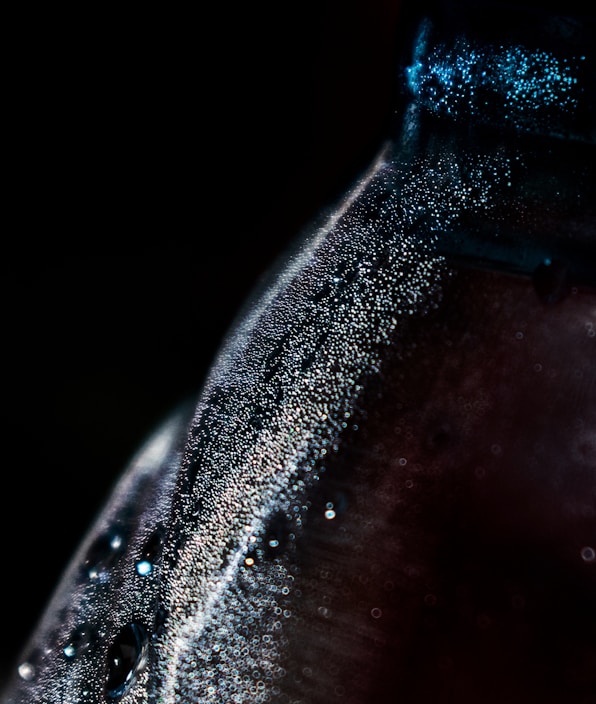 Close-up of a rich, dark coffee concentrate bottle with condensation droplets on the glass.