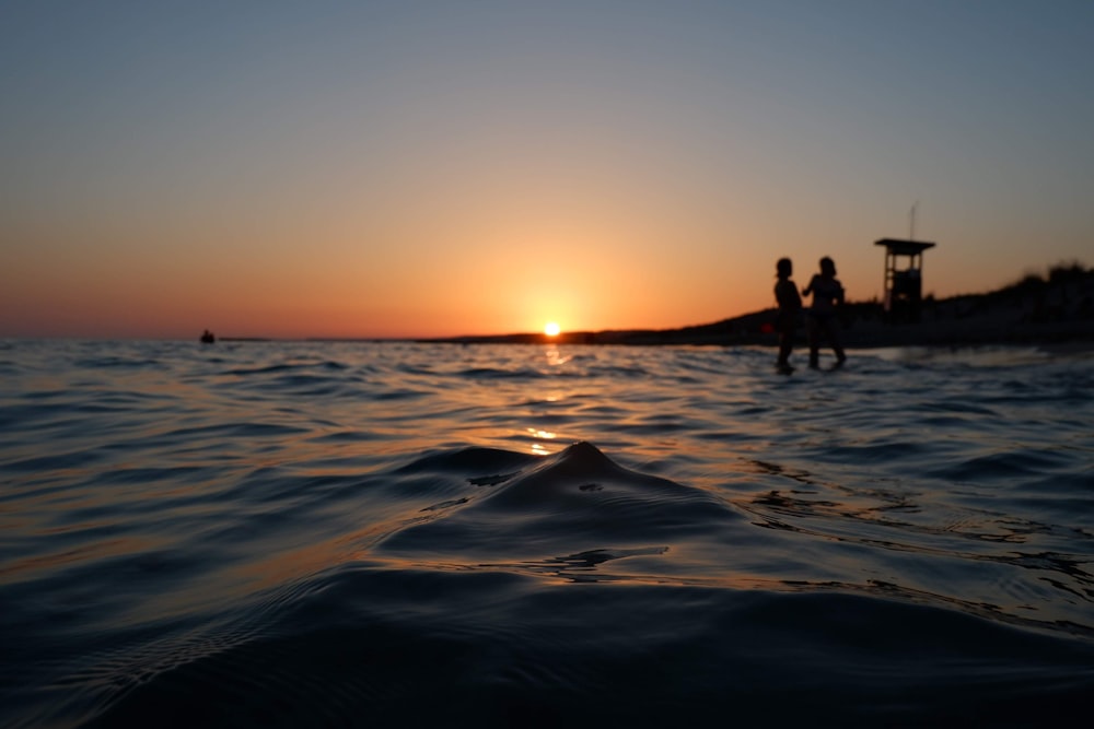 silhouette of people on beach during sunset