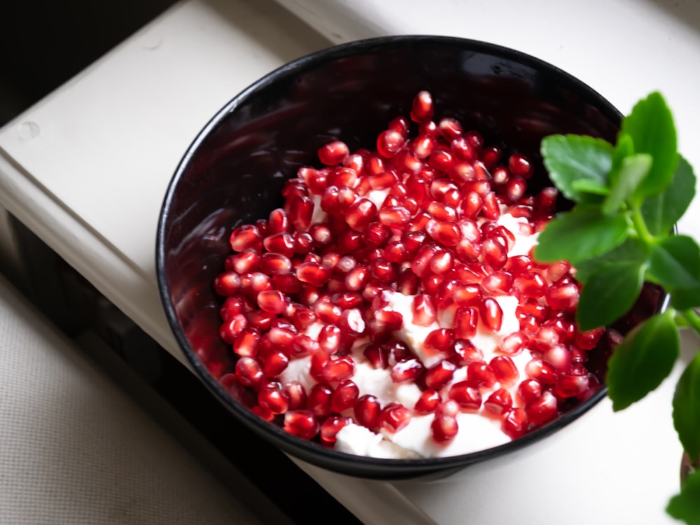 red round fruit on black ceramic bowl