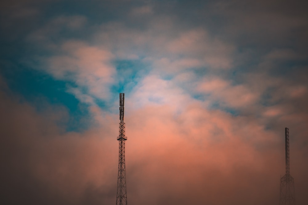 silhouette of tower under orange and blue sky