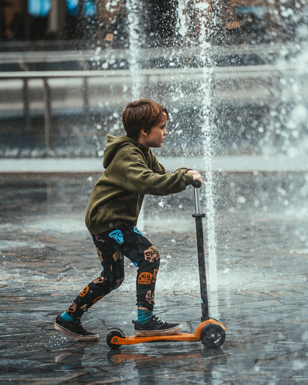 boy in brown jacket and black pants playing on water during daytime