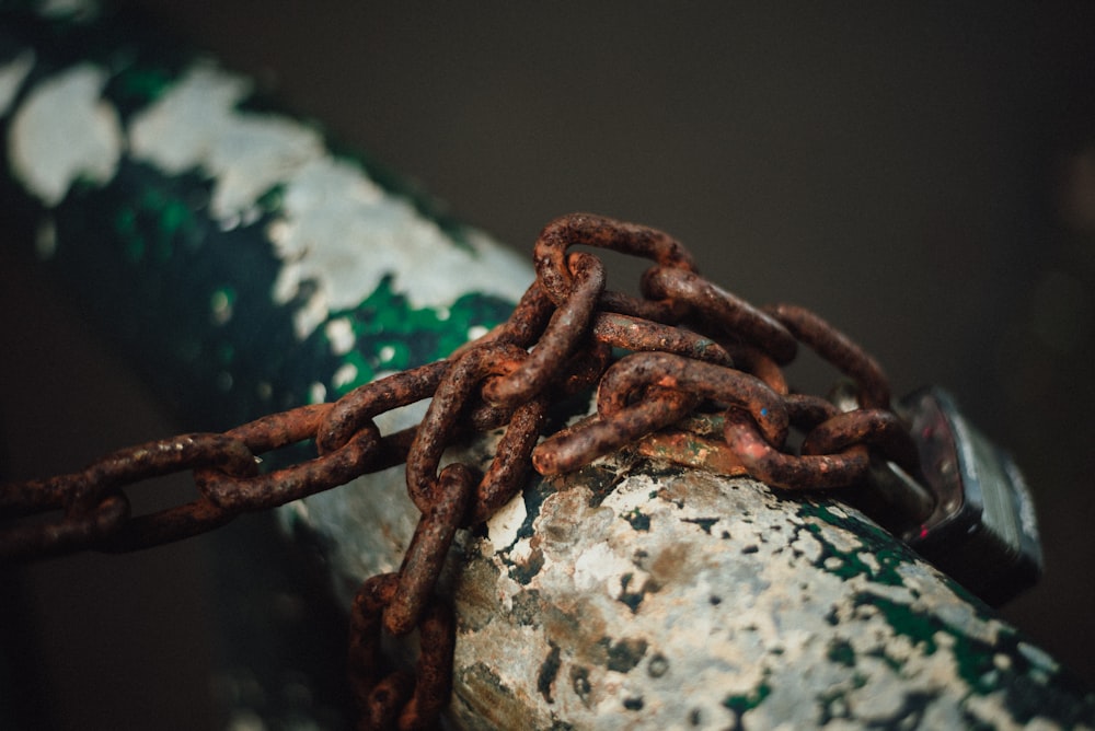 brown metal chain on white rock