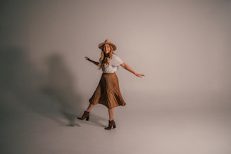 A joyful model twirling in a frilly pink dress and matching heels, radiating confidence and fun.