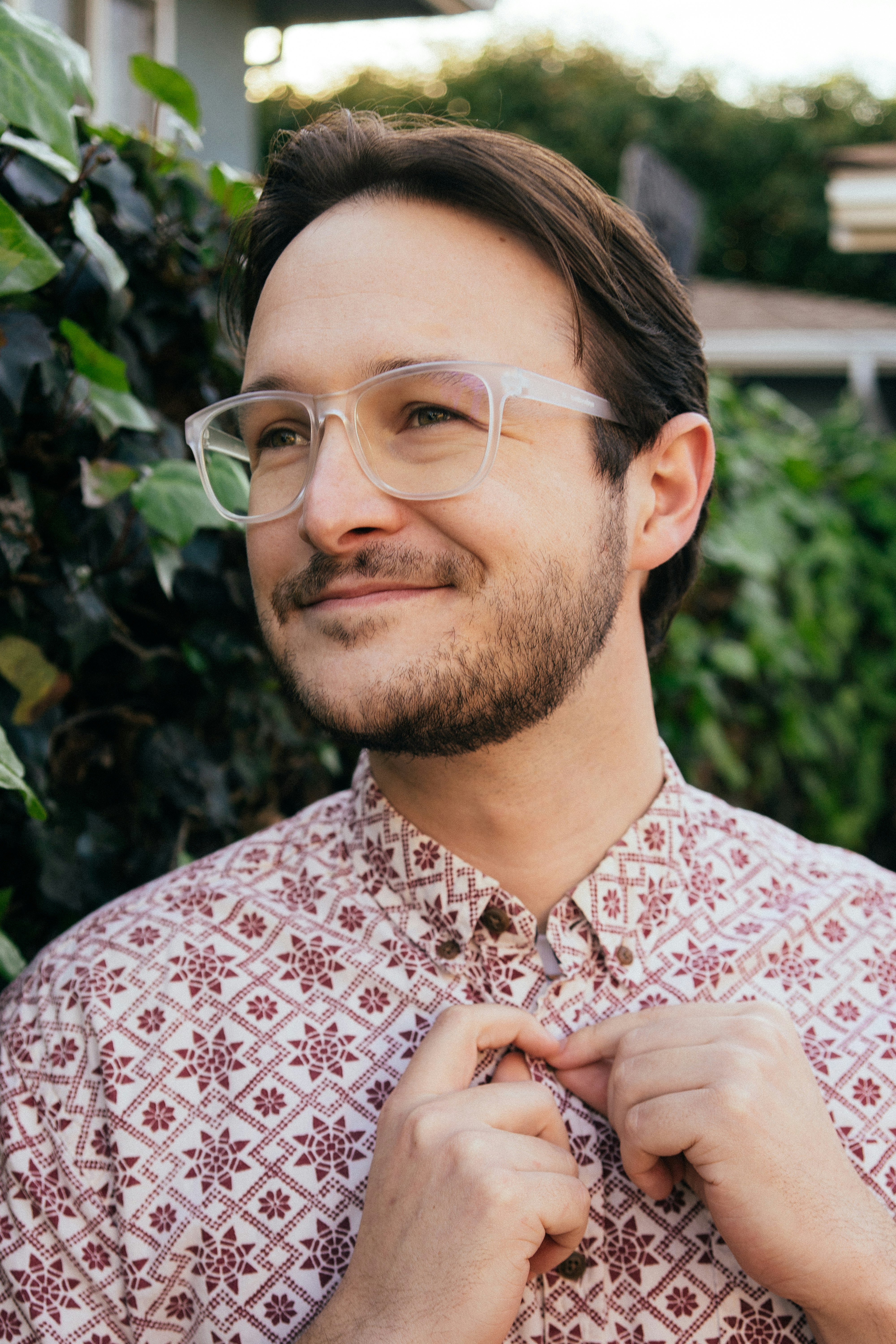 man in red and white floral button up shirt wearing eyeglasses